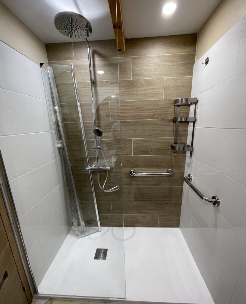 Douche moderne avec accessoires et carreaux bois PMR.