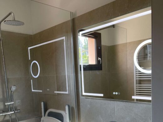 Salle de bain moderne accessible avec douche et siège PMR. Idéale pour projets de rénovation.